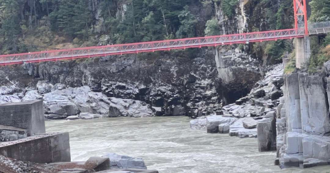 Scary red bridge over turbulent river
